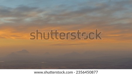 In this photo, the sky wears a shroud of billowing clouds. Their gentle drift across the heavens creates an ever-changing canvas of soft, muted tones. Royalty-Free Stock Photo #2356450877