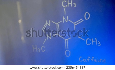 Chemical structure, formula of caffeine on glass in the lab close-up. Lecture on chemistry. Blue background