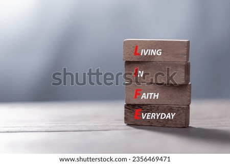 LIFE living in faith everyday symbol. Concept words LIFE living in faith everyday on wooden blocks on beautiful wooden background. Business LIFE living in faith everyday concept. Copy space.