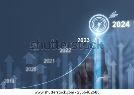 Businessman analyzing financial balance sheet of company working with digital virtual graphics. Businessman is calculating financial data for investment growth target in 2024 Royalty-Free Stock Photo #2356482683