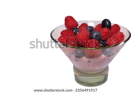 Raspberries and blueberries on fruit yogurt in jar
