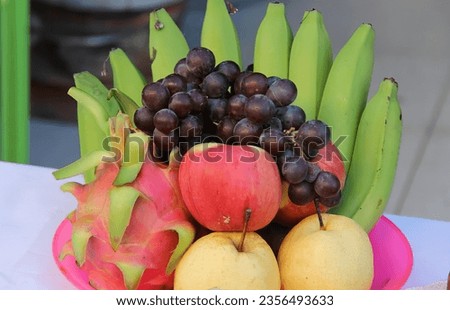 a photography of a bowl of fruit on a table with a banana, dragon fruit, and orange.