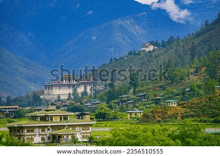 A beautiful photo of Bhutan's only international airport at Paro with the monumental Rinpung Dzong and Ta Dzong (watch tower) in the background Royalty-Free Stock Photo #2356510555