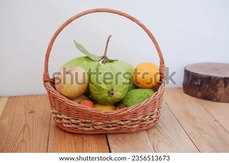  Basket of apples, oranges, guava and watermelon on a wooden table, stock photo