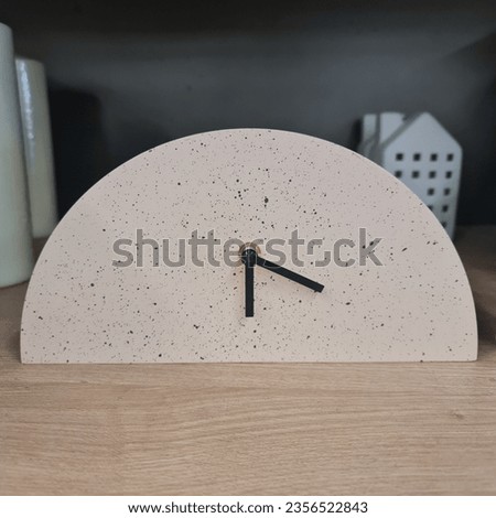 A modern, minimal clock finished in a nutmeg colour. 
