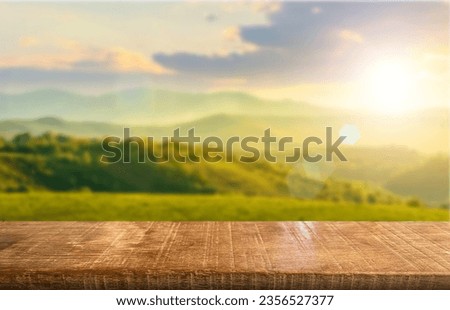 Wooden table top on blur mountain and grass field.Fresh and Relax concept.For montage product display or design key visual layout.View of copy space. Royalty-Free Stock Photo #2356527377
