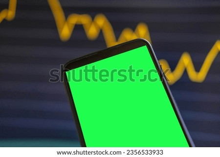 Black phone with blank mockup screen on rising stock graph. Closeup hand showing smartphone isolated green display. Online banking, Fund App use. Financial analyst on Invest Market. Bank collapse 2023