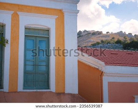 Cute details of windows, doors, balconies from old house in Simi island . Greece islands holidays from Rhodos in Aegean Sea. Colorful neoclassical houses in bay of Symi. Holiday travel background.