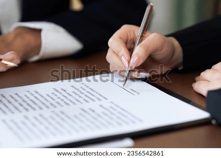 Close up businessperson or lawyer signing his signature to agreement document
