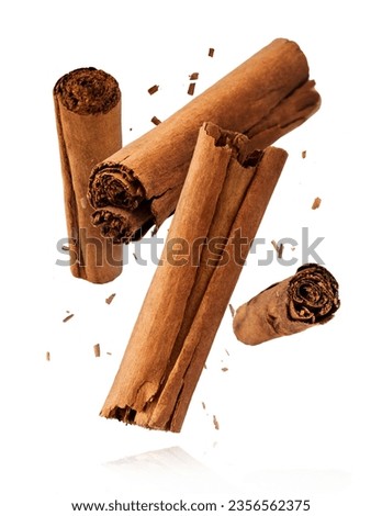 Fresh dried raw Cinnamon stick falling in the air isolated on white backround. Food spices levitation or zero gravity conception. High resolution image. Royalty-Free Stock Photo #2356562375