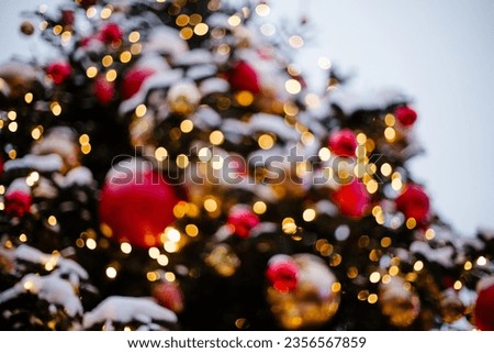 Blurred beautiful lights of a garland and a decorated Christmas tree view from below
