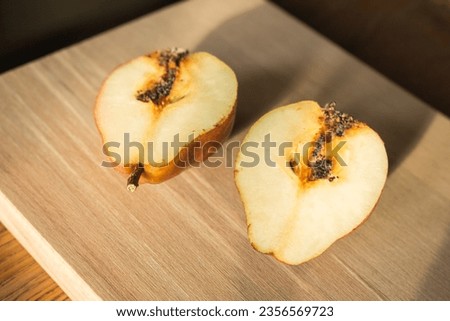 Damaged pears on wooden table. Peas with worm on cutting board. Juicy fruits. Autumn farming. Autumn harvest. Raw food. Slices of sweet pear. Organic fruits. Spoiled fruits.