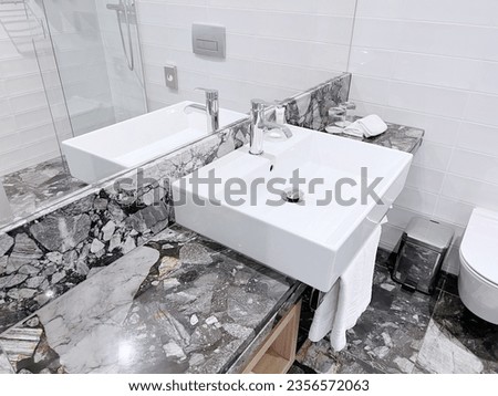 modern hotel bathroom, white ceramic sink with chrome metal faucet, sink fixture, bathroom detail, luxury hotel bathroom, white sink, chrome faucet, modern design for black and white restrooms Royalty-Free Stock Photo #2356572063