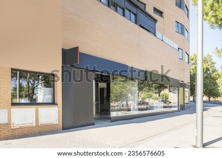 Image of a modern commercial premises at street level with a large glass front on a very bright day
