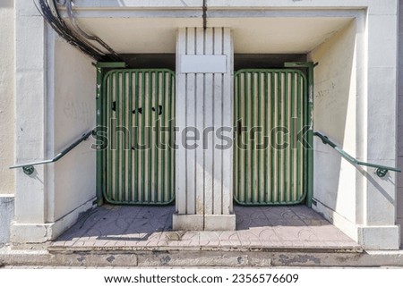 Green painted metal access portal with old twin doors