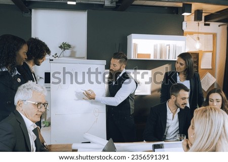 Manager showing business plan to colleagues and employees. Billboard with business strategy drawing and planning. Business meeting and discussion of results