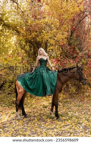 A woman in a long dress sits on a horse. Autumn forest, horse breeding