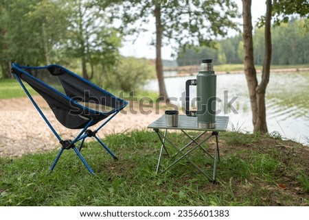 Green thermos camping in nature