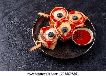 Monster Bloody Eyeballs for Halloween. Crepes roll up with banana and strawberry jam Royalty-Free Stock Photo #2356605851