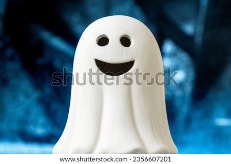 Cute Fun Happy Smiling White Toy Baby Ghost with blue Smokey spooky Halloween Background