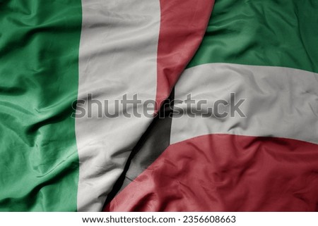 big waving national colorful flag of italy and national flag of kuwait . macro