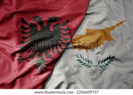 big waving national colorful flag of albania and national flag of cyprus . macro