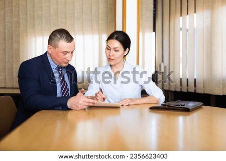 Asian woman signing apply for job agreement sitting in the meeting room at office