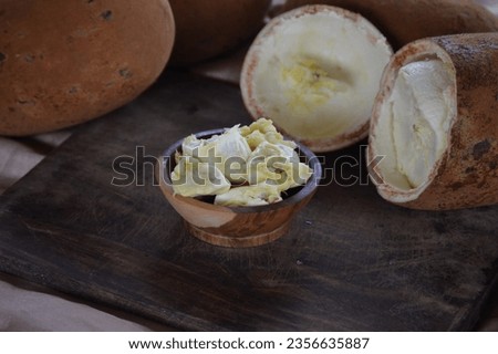 Cupuaçu pulp in the wooden bowl. Cupuacu fruit (Theobroma grandiflorum), malvaceae family, pulp and seeds of a tropical cupuacu fruit, Amazon, Brazil Royalty-Free Stock Photo #2356635887