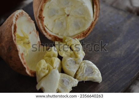 Pulp of fresh cupuaçu fruit coming out of the open fruit on the wooden board. Cupuacu fruit (Theobroma grandiflorum), malvaceae family, pulp and seeds of a tropical cupuacu fruit, Amazon, Brazil Royalty-Free Stock Photo #2356640263