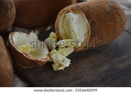 Pulp of fresh cupuaçu fruit coming out of the open fruit on the wooden board. Cupuacu fruit (Theobroma grandiflorum), malvaceae family, pulp and seeds of a tropical cupuacu fruit, Amazon, Brazil Royalty-Free Stock Photo #2356640399