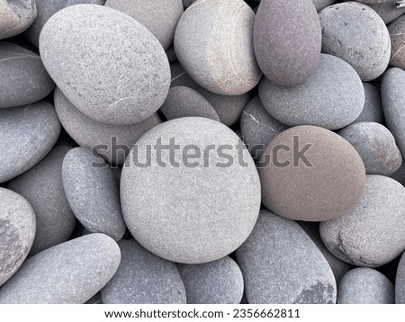 close-up of round pebbles on beach. Grey stone background
