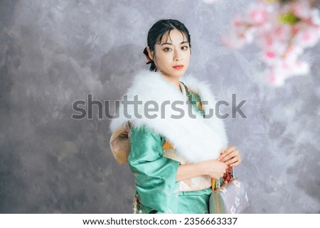 Portrait of an Asian woman wearing furisode. Japanese traditional dress. Pre-photoshoot at a photo studio for graduation ceremonies or coming-of-age ceremonies. Oriental beautiful woman. Royalty-Free Stock Photo #2356663337