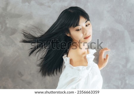 Fashion portrait of young Asian attractive woman blowing her long black hair. Hair care concept. cosmetics. Beauty salon. Royalty-Free Stock Photo #2356663359