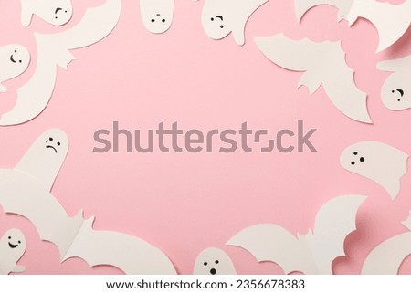 Paper ghosts and bats on pink background, space for text