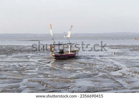 the fishing boat is leaning on kenjeran beach where the sea is receding on September 3, 2023