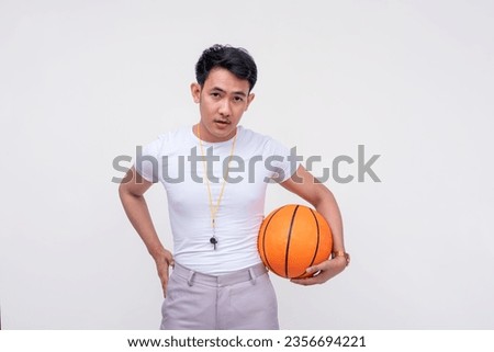 A handsome and confident FIlipino guy in a white shirt wearing a whistle and holding a basketball. Isolated on a white background.