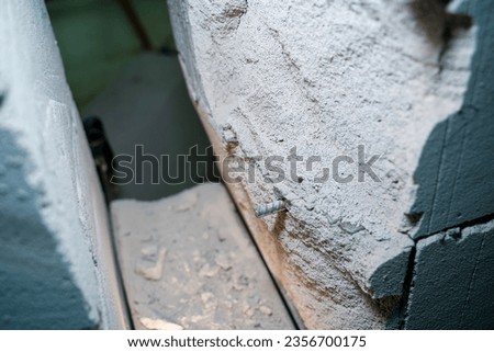 The wall of aerated concrete bricks is cut through close-up. Metal reinforcement in a gas block wall Royalty-Free Stock Photo #2356700175