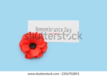 Red poppy flower with card on blue background. Remembrance Day in Canada Royalty-Free Stock Photo #2356702851