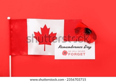 Poppy flower, flag of Canada and card on red background. Remembrance Day