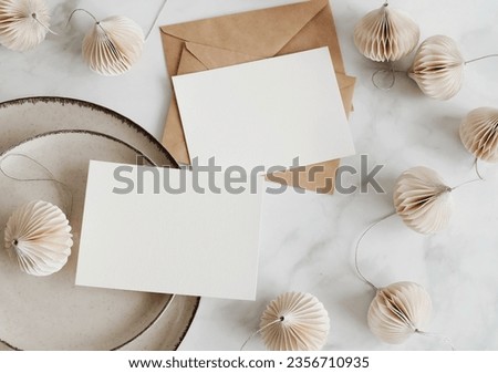 Cards mockup, envelopes and christmas garland top view on white marble background with copy space. flatlay. Blank, greeting card template.