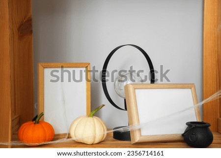 Shelf with frames and Halloween decoration in living room