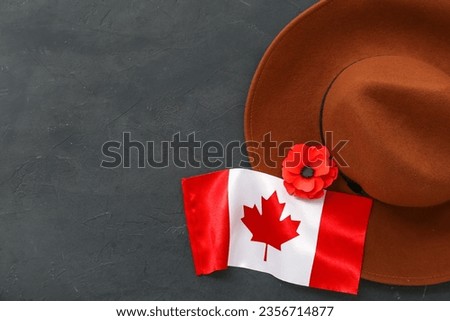 Poppy flower, hat and flag of Canada on black background. Remembrance Day