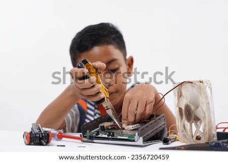 Schoolboy studying Robotic and electronic components at home