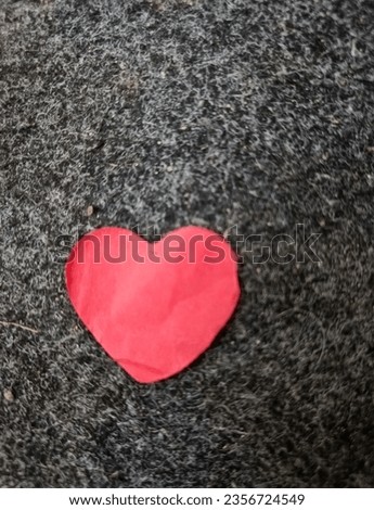 Heart-shaped pieces of paper scattered on the gray carpet