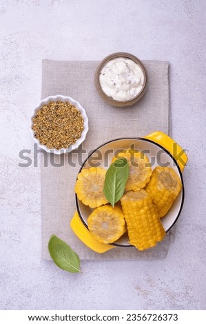 Chopped corn cobs in a ceramic dish on a light background. Top view.