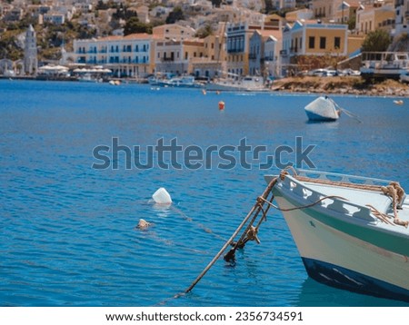 View on Symi or Simi island harbor port, classical ship yachts, houses on island hills, Aegean Sea bay. Greece islands holidays vacation travel tours from Rhodos island. Symi, Greece, Dodecanese.
