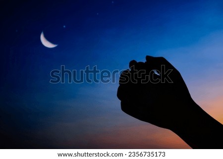 Hands of an Islamic man asking for blessings from the gods. Background with half moon and starry sky. The ray of hope holds an important place in Islam.