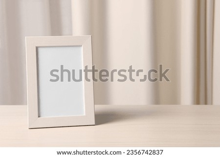 Empty square frame on white wooden table indoors, space for text
