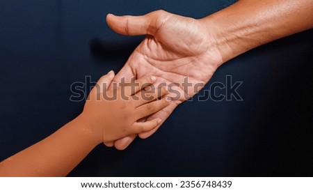 Man's father's palm looking after little baby's hand