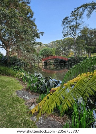 lake in botanical garden with red vintage bridge 